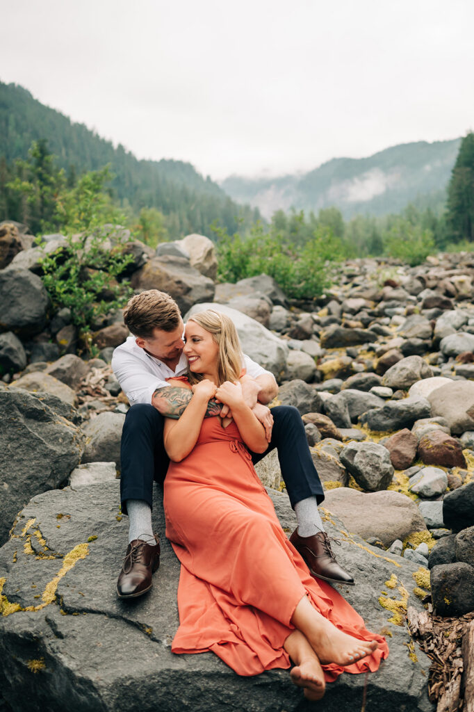 Couple photographed in a rocky riverbed during a Mount Rainier engagement session