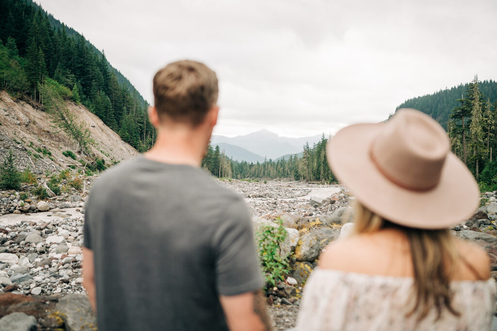 Couple photographed in a rocky riverbed during a Mount Rainier engagement session