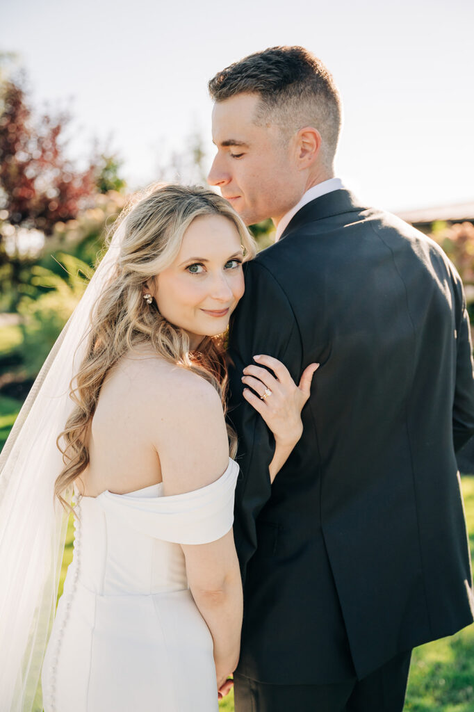 Bride hugging grooms arm on wedding day